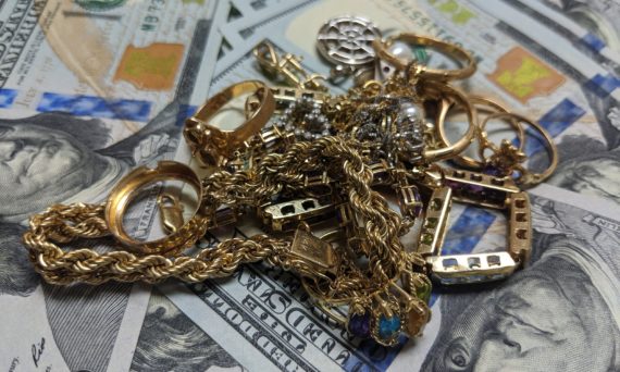 Pile of gold jewelry on laid out paper money in Des Plaines